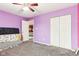 A bedroom with a ceiling fan, purple walls, white closets, and carpet flooring at 14402 Wolverton Way, Fishers, IN 46037