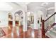 Open-concept living space with hardwood floors, arched doorways, and staircase at 14402 Wolverton Way, Fishers, IN 46037