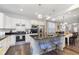 Bright kitchen boasts white cabinetry, stainless steel appliances, and a granite island with seating at 16613 Grappa Trl, Fishers, IN 46037