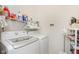 Efficient laundry room with modern washer and dryer, storage shelves, and organized cleaning supplies at 16613 Grappa Trl, Fishers, IN 46037