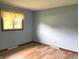 Inviting bedroom with light blue walls, wood floor, and a window offering natural light at 1701 Beech N Dr, Plainfield, IN 46168