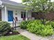 Welcoming front porch with a blue door, complemented by fern landscaping at 1701 Beech N Dr, Plainfield, IN 46168
