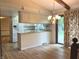 Open-concept kitchen and dining area featuring hardwood floors, white cabinets, and a view to the outside at 1701 Beech N Dr, Plainfield, IN 46168