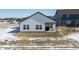 Backyard with a partially covered patio perfect for outdoor living, surrounded by a snow-covered lawn at 20170 Edwick Dr, Westfield, IN 46074