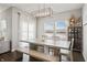 Dining area with an expansive wooden table, bench seating, and bright windows with farmland views at 20170 Edwick Dr, Westfield, IN 46074