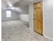 Attic room with light walls, carpet flooring, a window, and a wooden door at 205 S Market St, Thorntown, IN 46071