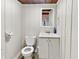 Cozy bathroom featuring a toilet, vanity, sink, and mirror on white wood walls at 205 S Market St, Thorntown, IN 46071