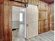 Bedroom featuring a sliding barn door and light wood plank flooring at 205 S Market St, Thorntown, IN 46071