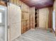 Bedroom with light-colored wood laminate flooring, wood paneled walls, and a barn door at 205 S Market St, Thorntown, IN 46071