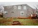 Backyard view of house with wooden deck and brick fire pit on green grass at 205 S Market St, Thorntown, IN 46071