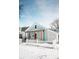 Charming home featuring a covered porch, pink front door, and white picket fence, all surrounded by a blanket of fresh snow at 205 S Market St, Thorntown, IN 46071