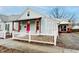 Home exterior featuring a pink door, covered porch with wood beams, and a classic white picket fence at 205 S Market St, Thorntown, IN 46071