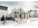 Exterior of a home with a pink door, cozy porch, and a white picket fence surrounded by a snowy landscape at 205 S Market St, Thorntown, IN 46071