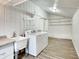 Well-lit laundry room with washer, dryer, sink, storage cabinets, and shelving at 205 S Market St, Thorntown, IN 46071