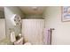Close up of a bathroom shower with white curtain, hexagon shelf, and tiled flooring at 2129 Heather Rd, Anderson, IN 46012