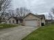 Charming brick house featuring a two-car garage, and a yard with a walkway and garden at 2129 Heather Rd, Anderson, IN 46012