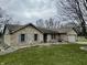 Charming single story tan brick home with a two car garage, blue shutters, and landscaped front yard at 2129 Heather Rd, Anderson, IN 46012