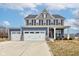 Charming two-story home featuring a three-car garage, blue and gray siding and a cozy front porch at 2627 Chalbury Dr, Plainfield, IN 46168