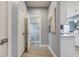 Hallway leading to the kitchen offers white doors, light flooring, and a glimpse of a nearby half bathroom at 2627 Chalbury Dr, Plainfield, IN 46168
