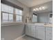 Bright primary bathroom featuring dual sinks, a vanity with white cabinets, and a large window at 2627 Chalbury Dr, Plainfield, IN 46168