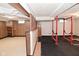 Basement space features wood-look floors, exposed pipes, exercise equipment, and wood paneling at 3533 N Grant Ave, Indianapolis, IN 46218