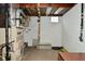 Utility area with a furnace, small window, and storage for flooring materials, providing essential home systems at 3533 N Grant Ave, Indianapolis, IN 46218