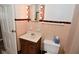 A vintage bathroom with a light-bulb vanity mirror, toilet, peach tiles, and a pedestal sink at 3533 N Grant Ave, Indianapolis, IN 46218