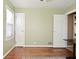 The bedroom is painted green with hardwood floors, two doors, and a large window at 3533 N Grant Ave, Indianapolis, IN 46218