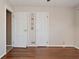 A bedroom with hardwood floors has two white doors and trim, with access to other rooms at 3533 N Grant Ave, Indianapolis, IN 46218