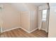Bedroom featuring wood-look floors, neutral wall panelling and a window with neutral curtains at 3533 N Grant Ave, Indianapolis, IN 46218