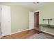 A bedroom with hardwood floors has two doors and a window that provide a comfortable atmosphere at 3533 N Grant Ave, Indianapolis, IN 46218