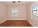 Bedroom with bright natural light from two windows complemented by classic hardwood flooring at 3533 N Grant Ave, Indianapolis, IN 46218