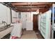 Laundry room featuring a washer, dryer, utility sink, and exposed ceiling beams at 3533 N Grant Ave, Indianapolis, IN 46218