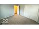 Bright bedroom features neutral paint and carpet, closet with double doors, and natural light at 3656 Allison Ave, Indianapolis, IN 46224