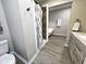 Modern bathroom featuring a shower with patterned curtain, vanity, tub, and wood-look flooring at 498 Johnson Ave, Franklin, IN 46131