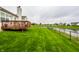 Lush backyard with a well-maintained lawn, a pond, and a wooden deck at 5650 Goodwin St, Indianapolis, IN 46234