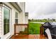 Back deck with table, chairs, and grill overlooking lush yard and pond at 5650 Goodwin St, Indianapolis, IN 46234