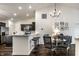 Bright open-concept dining area featuring modern lighting, dark wood floors, and a kitchen with white countertops at 5650 Goodwin St, Indianapolis, IN 46234