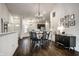 Bright open-concept dining area featuring modern lighting, dark wood floors, and a view to the kitchen at 5650 Goodwin St, Indianapolis, IN 46234