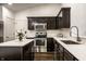 Modern kitchen featuring dark wood cabinets, stainless steel appliances, and marble countertops at 5650 Goodwin St, Indianapolis, IN 46234