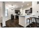 Stylish kitchen with dark cabinets, stainless steel appliances, a breakfast bar, and modern pendant lighting at 5650 Goodwin St, Indianapolis, IN 46234