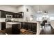 Modern kitchen featuring dark cabinets, stainless steel appliances, and an open view to the living area at 5650 Goodwin St, Indianapolis, IN 46234