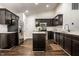 Updated kitchen with dark cabinets, stainless steel appliances, a center island, and wood flooring at 5650 Goodwin St, Indianapolis, IN 46234