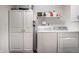 Well-organized laundry room with white cabinets and modern washer and dryer at 5650 Goodwin St, Indianapolis, IN 46234