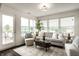 Bright living room with decorative rug, and natural light from the expansive windows and a glass door to the backyard at 5650 Goodwin St, Indianapolis, IN 46234