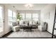 Bright living room with decorative rug, and natural light from the expansive windows and a glass door at 5650 Goodwin St, Indianapolis, IN 46234