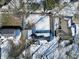 An aerial view of a neighborhood with houses, trees, and snow-covered yards during winter at 717 Washington Ct, Anderson, IN 46011