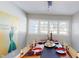 Dining room with hardwood floors, silver tea service, and natural light from large windows at 717 Washington Ct, Anderson, IN 46011