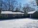 The back of a gray home with a snow-covered yard, featuring multiple windows and a door at 717 Washington Ct, Anderson, IN 46011