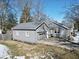 A gray home featuring an attached garage and driveway, situated in a neighborhood with trees at 717 Washington Ct, Anderson, IN 46011